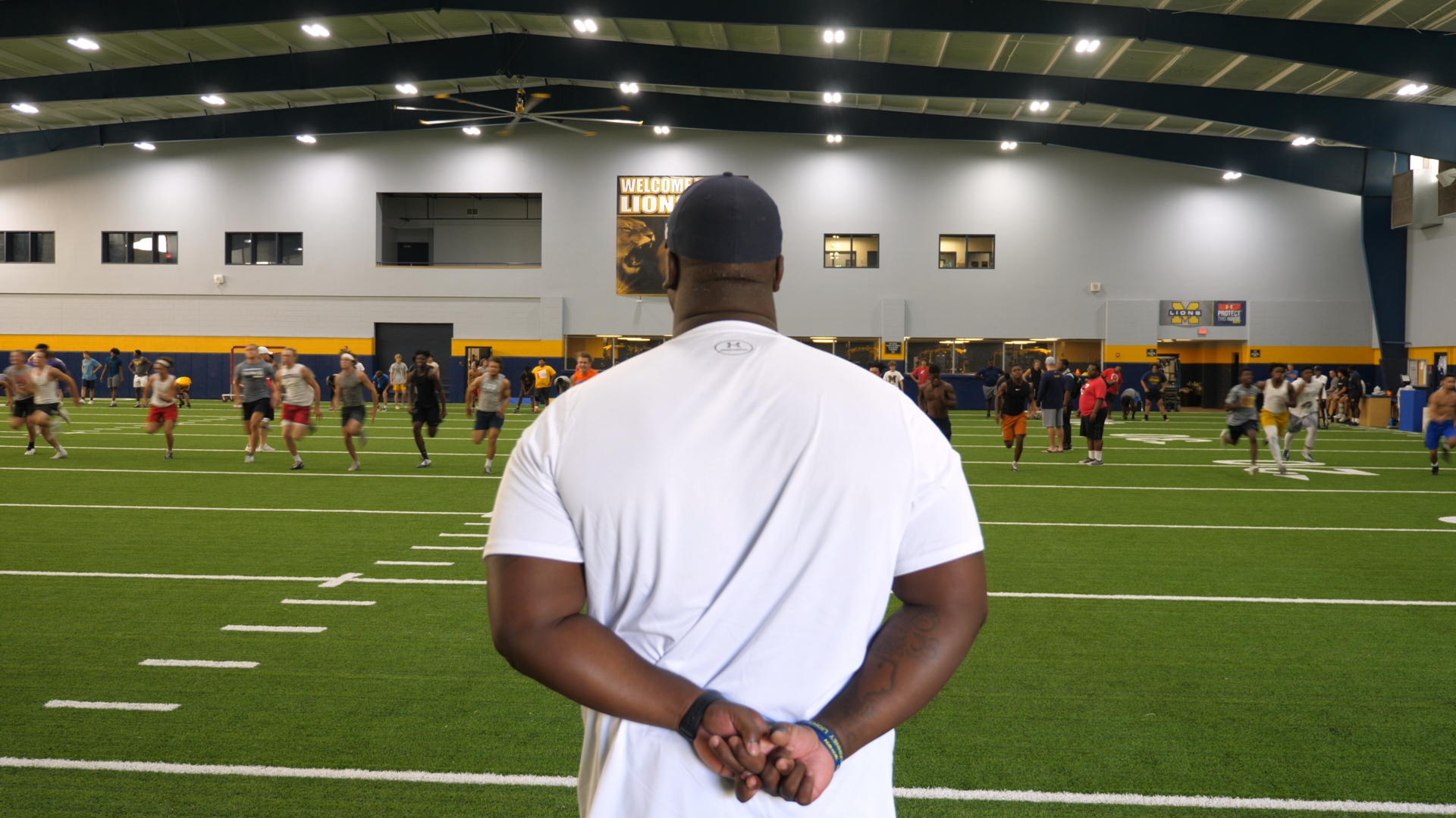 coach marcus shavers leading an indoor football practice at McKinny High Schol